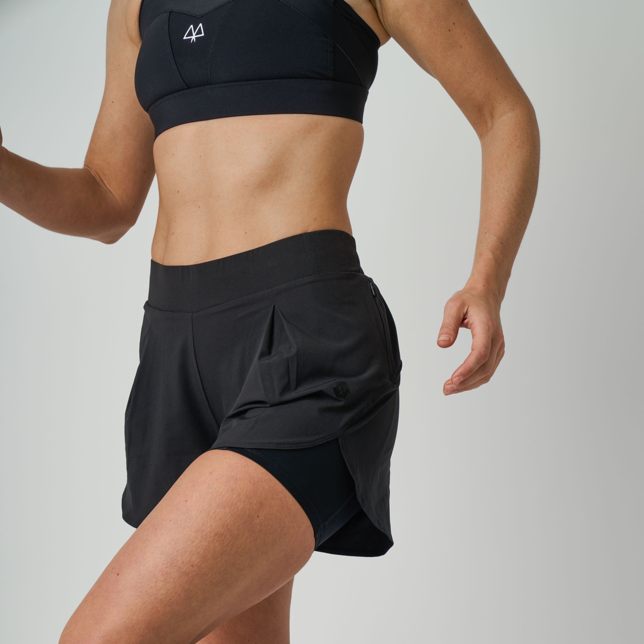 Person wearing a black athletic outfit on a plain background