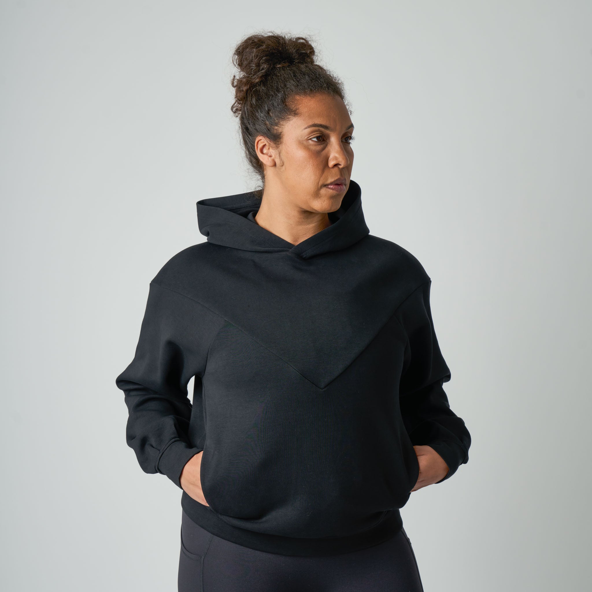 Person wearing a black hoodie against a plain background