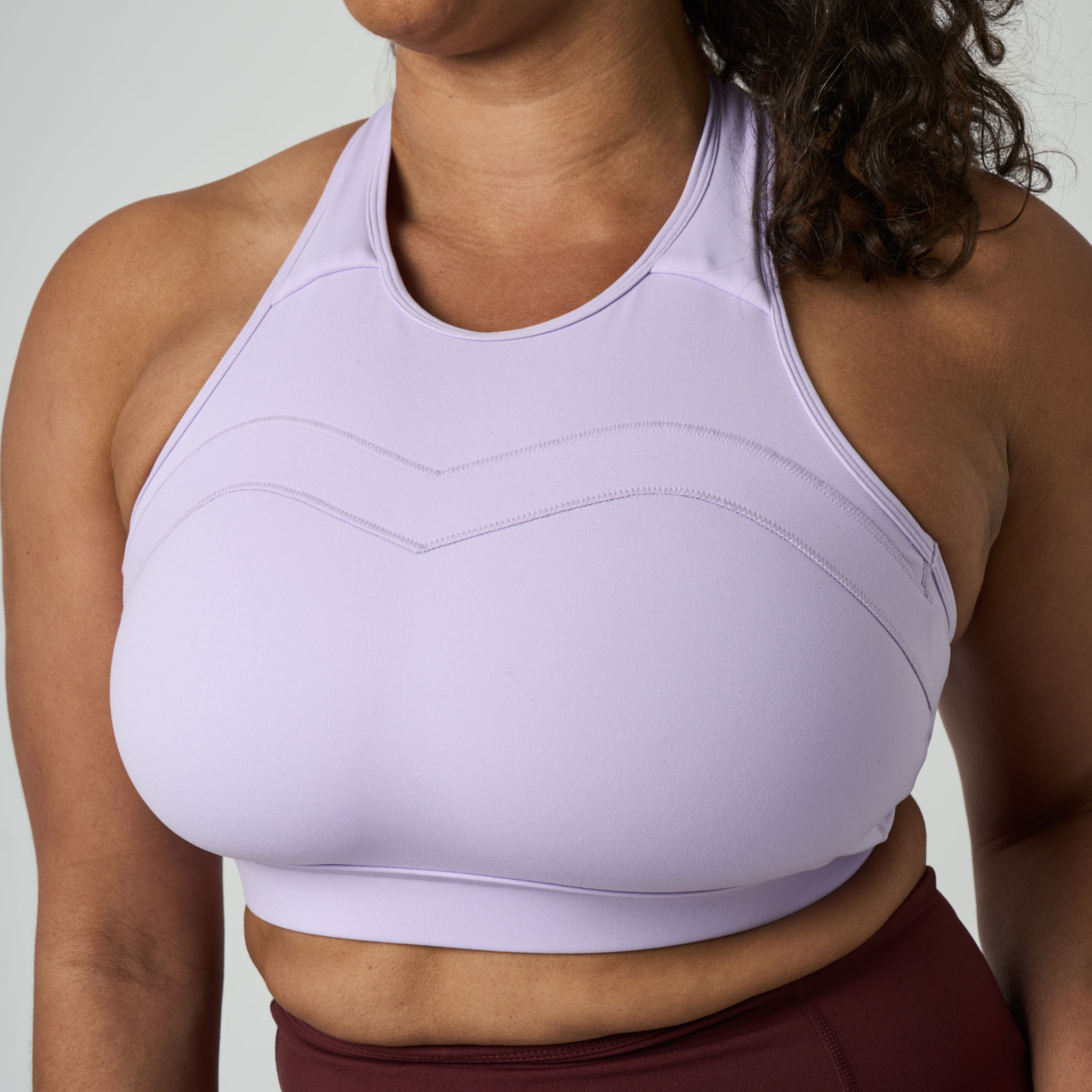 Person wearing a light purple sports bra against a neutral background